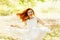 Happy beautiful ginger girl in a flying white vintage dress in t