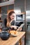 Happy beautiful girl touching her tablet in kitchen with croissants