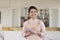 Happy beautiful Indian waitress in uniform apron holding pen