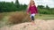 Happy beautiful little girl, adorable curly blond toddler, walking in sand dunes