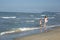 Happy beautiful mom and child have fun in water at the sea beach