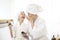 Happy beautiful mom and daughter in white bathrobe applying natural Make-Up with cosmetic powder brush, Family and Beauty Concept