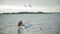 Happy and beautiful mother and daughter are feeding gulls on the beach on the river bank