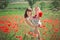 Happy beautiful mother lady posing with her cute little daughter in lovely scene of family summer life on meadow of daisy poppy fl