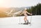 Happy beautiful naked girl skier posing on the snowy slope with ski equipment