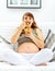 Happy beautiful pregnant woman eating fruit salad