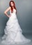 Happy beautiful red haired bride on gray background