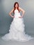 Happy beautiful red haired bride on gray background