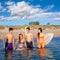 Happy beautiful teen surfers enjoying on beach