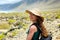 Happy beautiful traveler girl with straw hat looking to the camera. Young female backpacker exploring Lanzarote, Canary Islands.