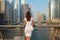 Happy beautiful unrecognizable tourist woman in fashionable summer white dress enjoying in Dubai marina in United Arab Emirates.