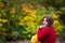 Happy beautiful woman in autumn, cute plus size model in red sweater outdoors with copy space