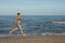 and happy beautiful woman in bikini running on the beach. In a cap with the inscription queen. Film effect.