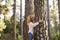 Happy beautiful woman embrace big tree trunk enjoying outdoors nature leisure activity - save the planet and earth`s day concept