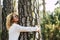 Happy beautiful woman love nature hugging a pine tree - no deforestation concept and earth`s day celebration - save our planet fo