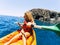 Happy beautiful woman in outdoor leisure activity doing kayak trip at the ocean - enjoying summer holiday vacation with sport