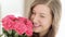 Happy beautiful woman smiling, receiving bouquet of rose flowers as floral holiday gift, romantic present and love