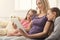 Happy beautiful woman using digital tablet and her daughters sleeping