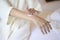 happy beautiful woman in white bathrobe applying body moisturizing cream in bedroom, skin care and treatment concept