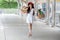 Happy beautiful young asian woman wearing white dress and sunglasses ,red hat with shopping bags over mall enjoying on street in