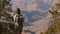 Happy beautiful young woman with backpack walking up to amazing summer landscape scenery of Grand Canyon slow motion.