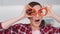 Happy beautiful young woman playing with food, using two cut slices of bell paper as glasses while cooking in the new