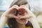 Happy beautiful young woman with rainbow lgbtq eyelashes making heart sign with her hands