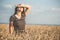 Happy beautiful young woman walking on wheat field with ripe spikelets, girl breathe breathes deeply , freedom and relaxation