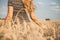 Happy beautiful young woman walking on wheat field with ripe spikelets, girl breathe breathes deeply , freedom and relaxation