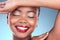 Happy, beauty and black woman with makeup, cosmetics and skincare on a blue studio background. Shine, African person or