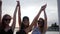 Happy best girlfriends dancing in the sunset on beach, three female raises arms up on seaside, summer evening