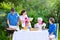 Happy big family eating grilled meat in garden