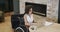Happy biracial businesswoman in wheelchair using laptop at desk in office, in slow motion