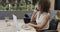 Happy biracial businesswoman in wheelchair using laptop and talking on smartphone, in slow motion