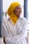 Happy biracial businesswoman with yellow hijab outside modern office