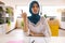 Happy biracial casual businesswoman with hijab having video call in creative office