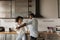 Happy biracial couple dance in own kitchen