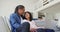 Happy biracial couple sitting on couch using laptop in living room