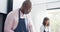 Happy biracial couple wearing aprons and cutting fresh bread in kitchen, slow motion