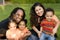 Happy biracial family with triplets at a park.