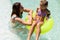 Happy biracial mother and daughter playing together in swimming pool