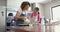 Happy biracial mother and daughter pouring cake mix, baking in kitchen, copy space, slow motion