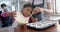 Happy biracial mother and daughter pouring cake mix into cake forms in kitchen, slow motion