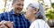 Happy biracial senior couple dancing in sunny garden