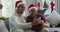 Happy biracial son with father in santa hats doing video call on smartphone in christmas