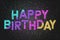 Happy Birthday Banner with colored confetti  text on black background. Elegant luxury Greeting card.