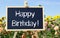 Happy Birthday - chalkboard with text in the garden