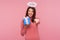 Happy birthday to you! Angelic brunette woman with nimbus over head giving present and pointing finger to camera, sharing holiday