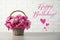 Happy Birthday! Wicker basket with pink peonies on table near white brick wall