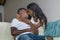 Happy black afro American couple cuddling at home living room sofa couch smiling cheerful having fun relaxed and cozy in